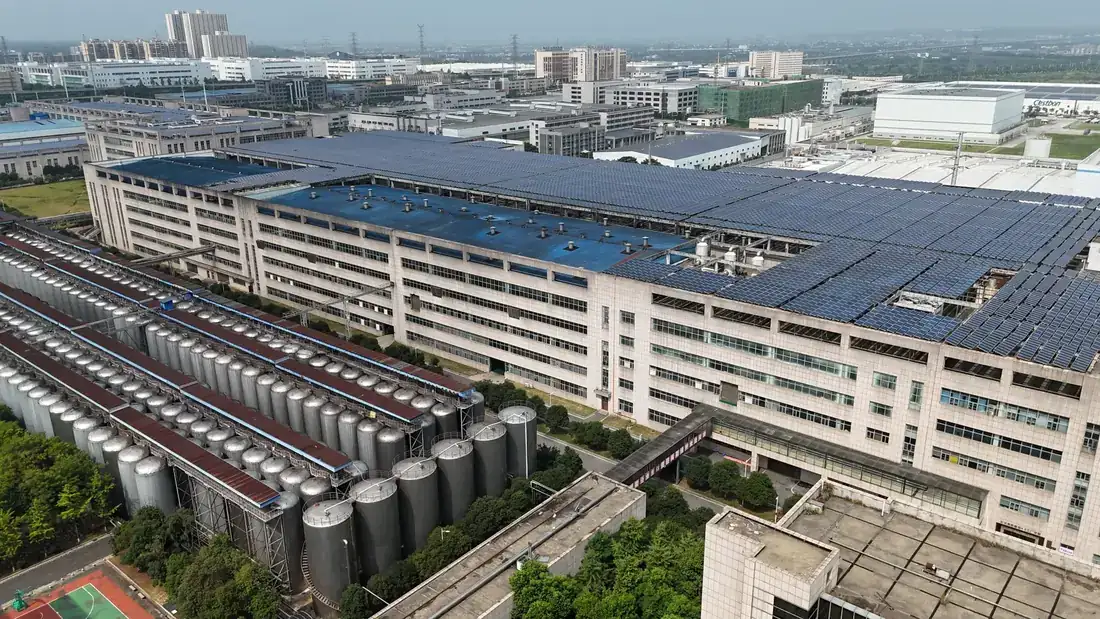 Aerial view of a factory roof fully covered with solar modules.